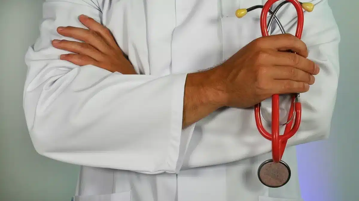 Doctor crossing his arms and holding a red stethoscope in his right hand