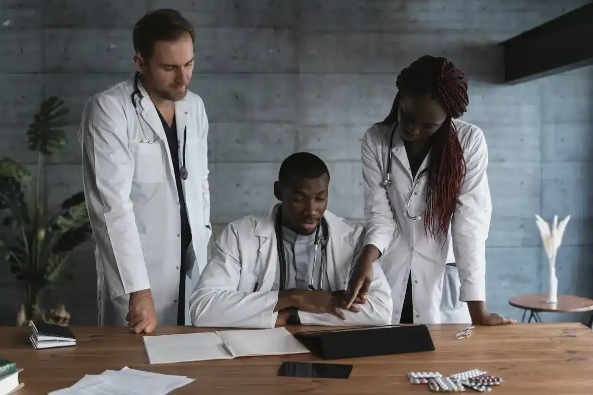 Three doctors checking notes of a patient
