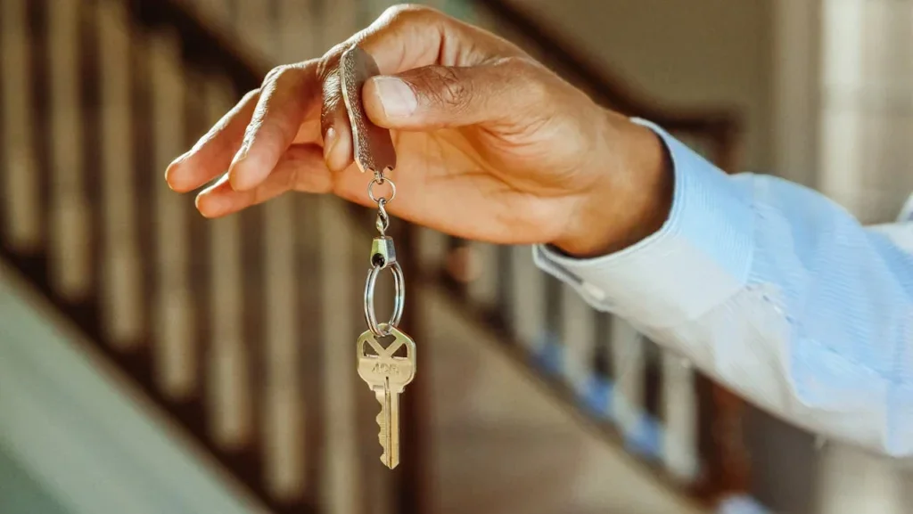 A person holding keys for an apartment that is up for rent