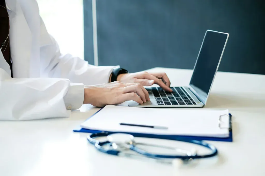 Doctor using laptop to check the clinic's website
