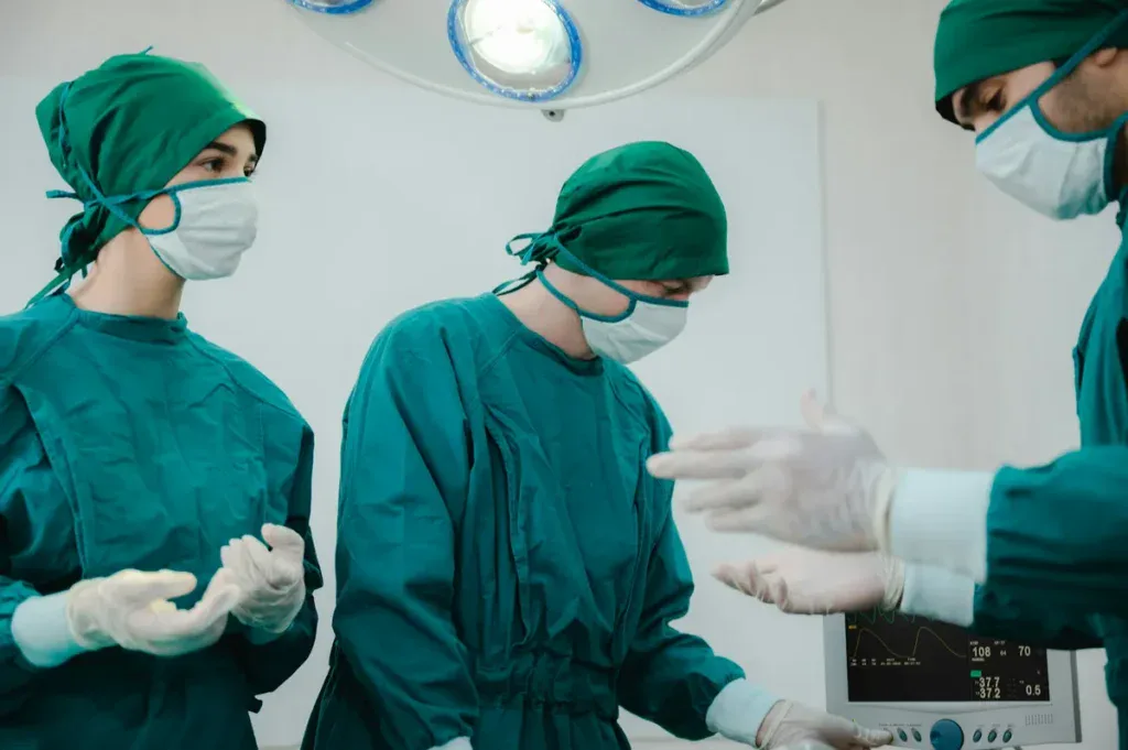 Doctor and nurses mid operation with green attires