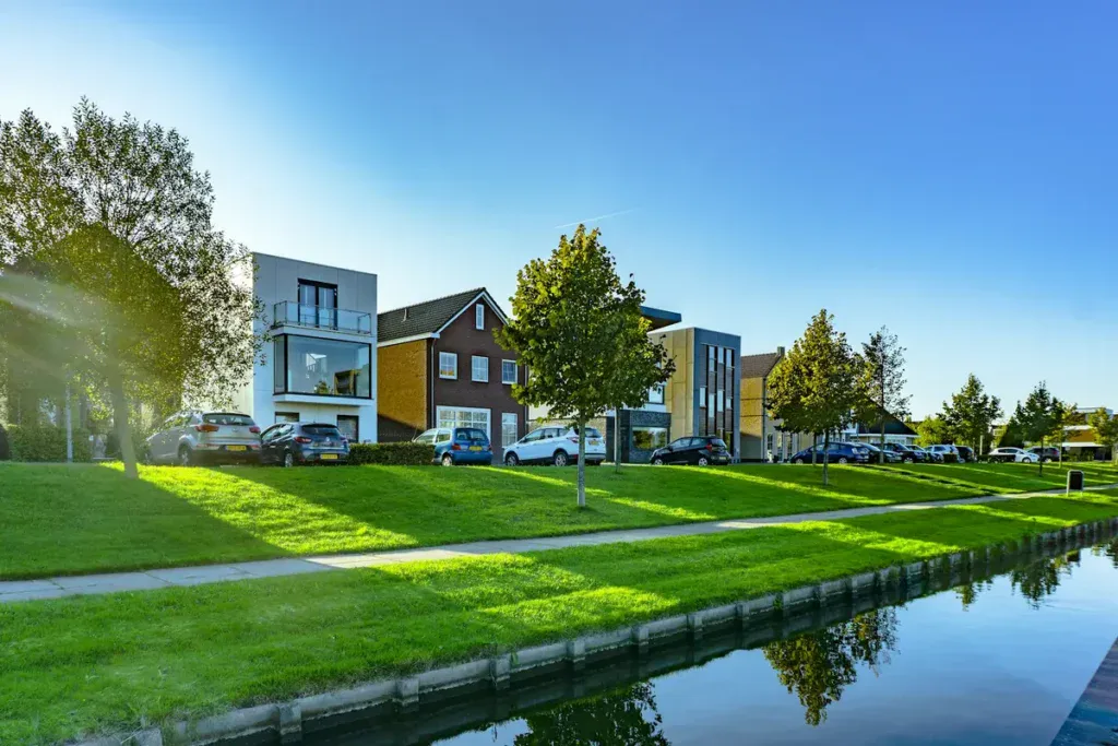 Houses near a river with strip of grass inbetween